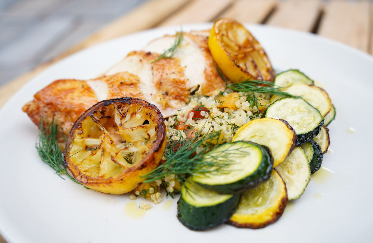 Grilled chicken with charred lemon, zucchini, and herbed grains